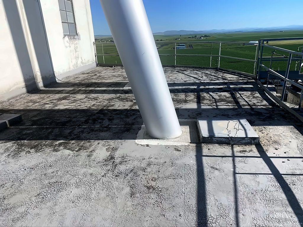 Before: CHS grain silo roof in Grangeville, Idaho, with a weathered concrete surface around the silo supports